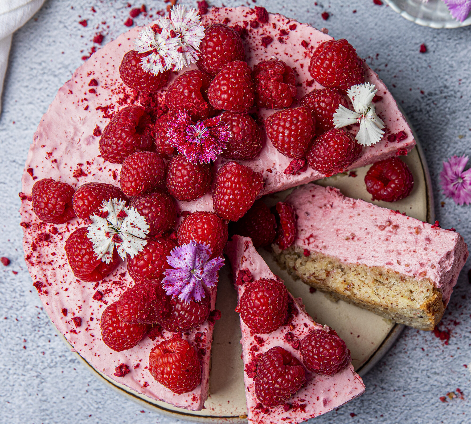 Bringebaer og yoghurtmoussekake med nottebunn toppet med spiselige blomster