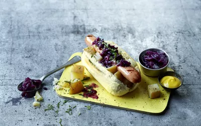 Grillpølse med rødkål, potetterninger og søt sennep toppet med bladpersille
